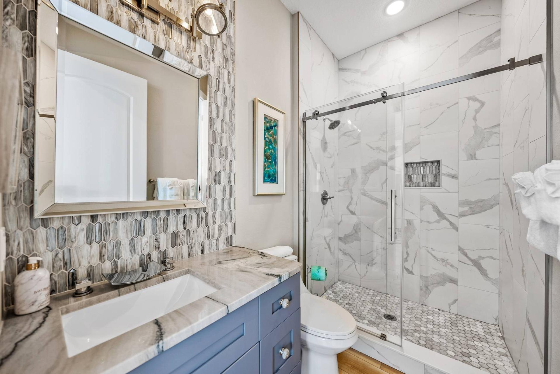Designer bathroom with marble shower and mosaic tile