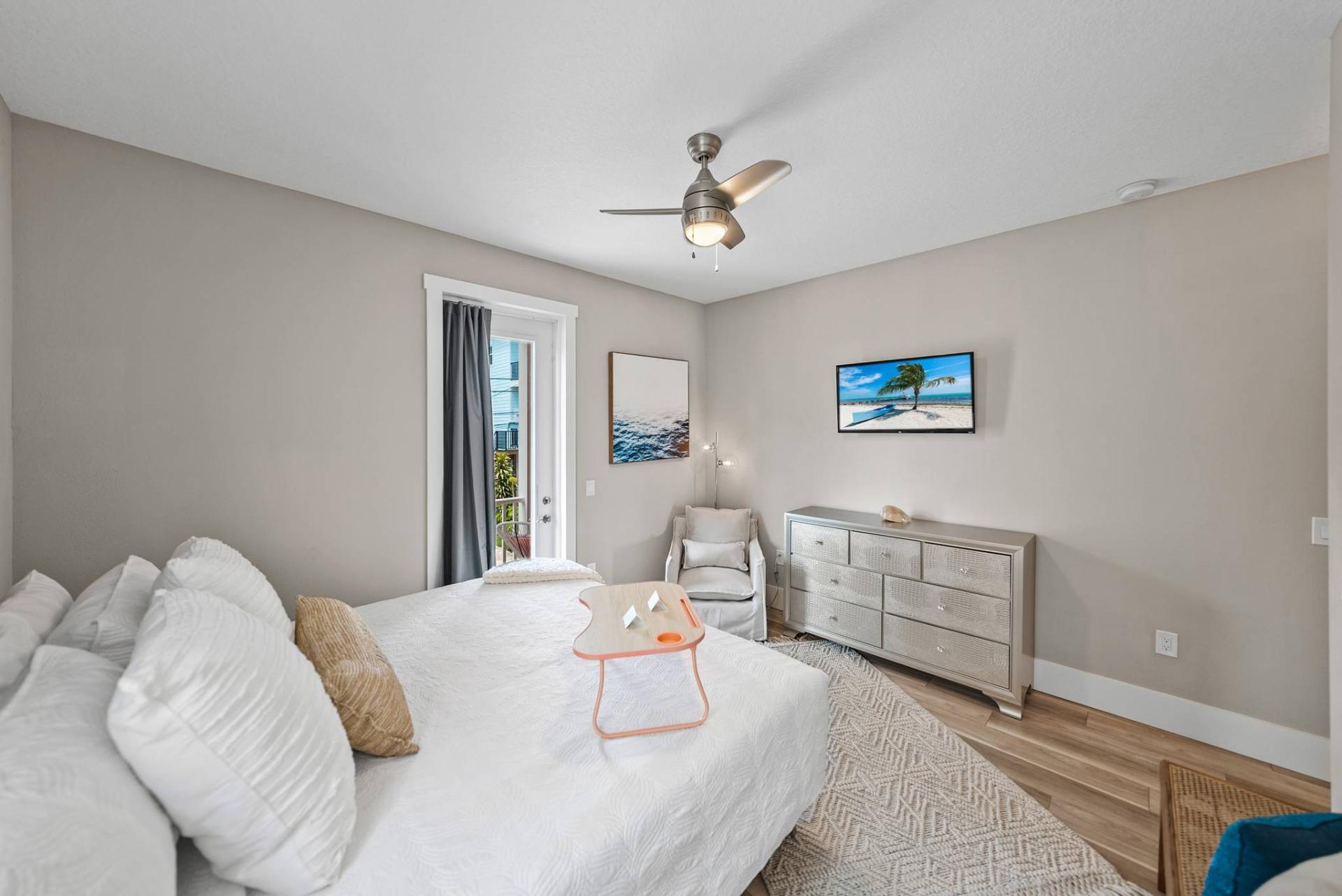 Bedroom with king bed, dresser, and balcony access