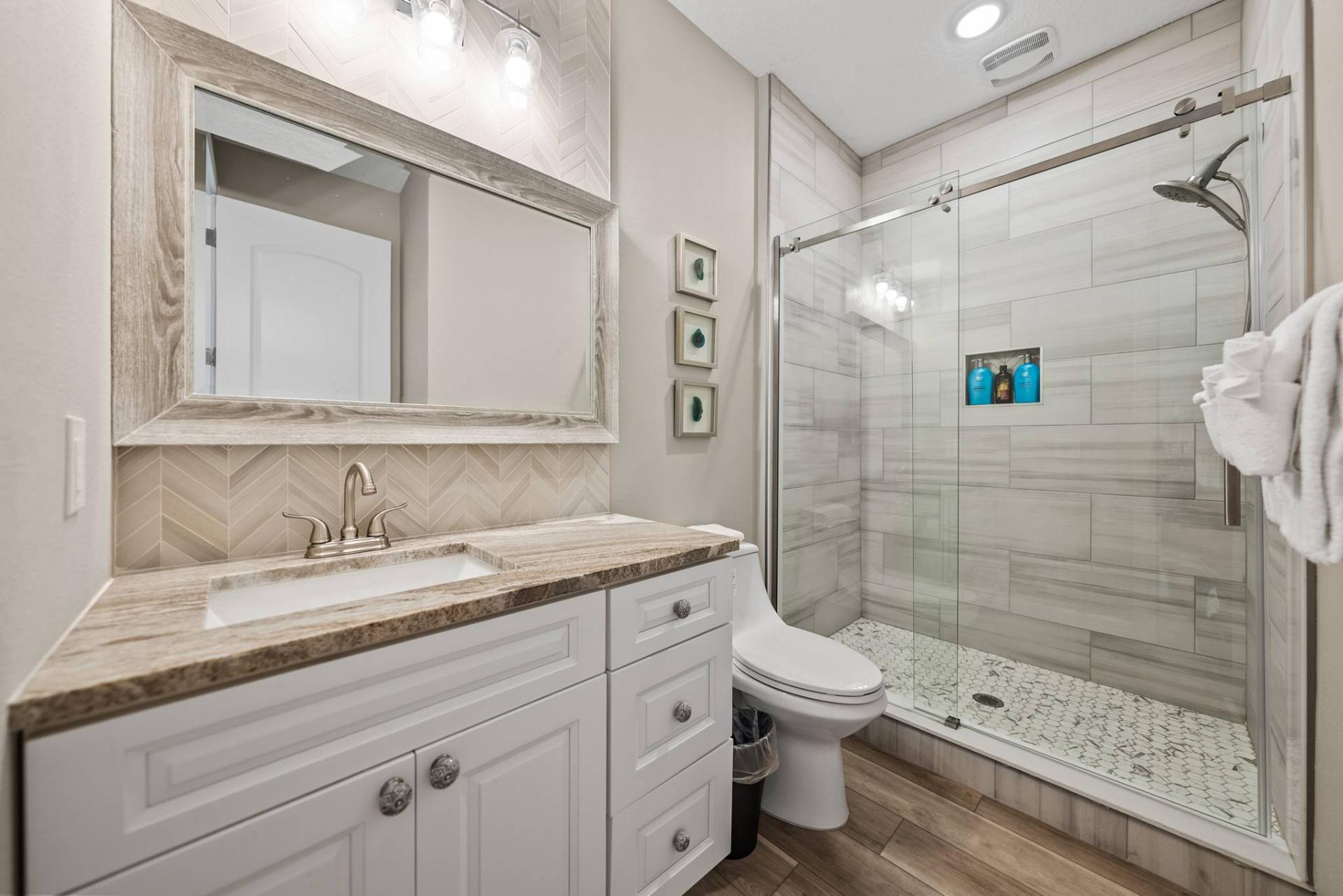 Guest bath with walk-in glass shower and chevron accent